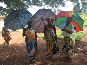 Women pause so that I can take images of them with their umbrellas. They remind me of African "Geishas"